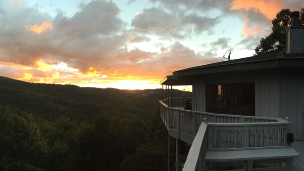 A house with a balcony overlooking a forested valley during sunset. - Marvelous Panoramic Mountain Views All Year, Private,Club,Skiing Slopes nearby! (Beech Mountain)