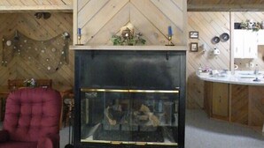 A cozy living room with a fireplace, a stone table, and a red armchair. - Marvelous Panoramic Mountain Views All Year, Private,Club,Skiing Slopes nearby! (Beech Mountain)