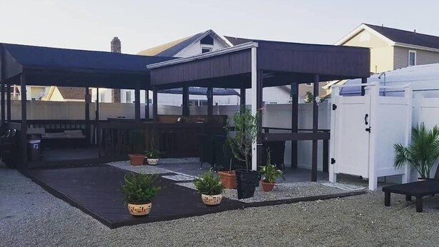 A covered outdoor patio area with seating and potted plants. - The Carters Wildwood Rentals-Suite #2 (Wildwood)