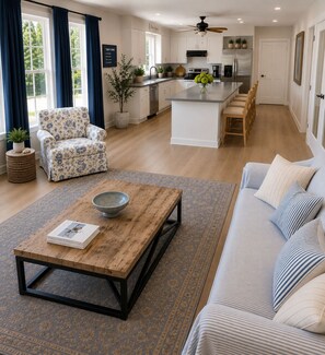 A modern living room with a wooden coffee table, a sofa, and a chair. - Bay Head - Open Concept Home with Water View (Point Pleasant)