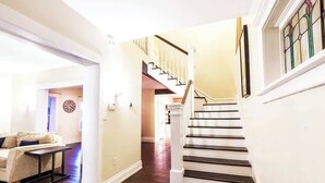 Eine Treppe mit weißen Geländern und dunklen Stufen, die zu einer oberen Etage führt.
