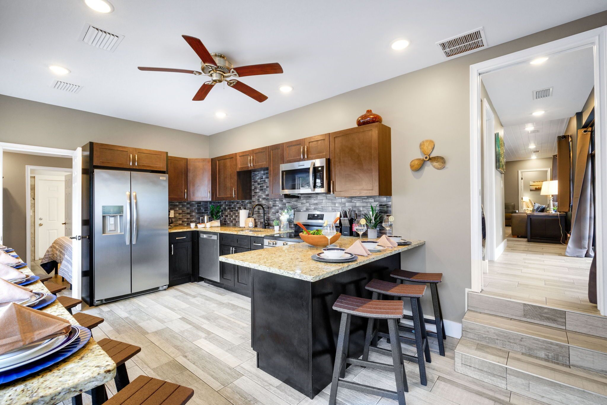 A modern kitchen with a central island, stainless steel appliances, and wooden cabinets.