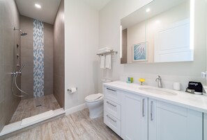 A modern bathroom with a shower, toilet, and vanity.