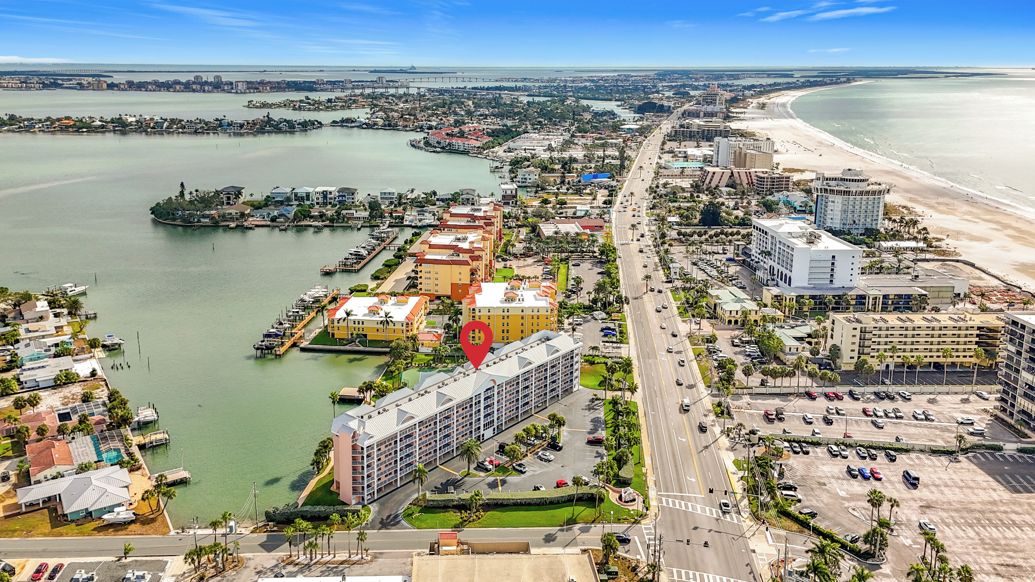 Un paysage urbain côtier avec un port de plaisance, des hôtels et une plage.