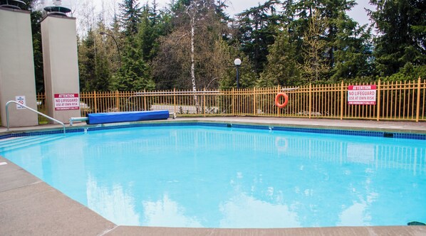 A swimming pool with a yellow safety fence, a lifeguard sign, and a 5 ft depth marker.