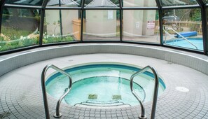 An indoor swimming pool with a tiled floor and metal pool ladders. - The Marquise, Steps from Slopes, Pool and Hot Tub, Patio, Free Shuttle (Whistler)
