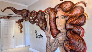 Un pasillo con un mural de una mujer de cabello largo y ondulante, y tatuajes en el brazo.