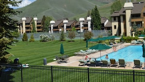 A hotel with a swimming pool, lounge chairs, and a view of mountains. - Wildflower Condo 655 - Third Floor Penthouse w/ Baldy Views & Sun Valley Pool (Sun Valley)