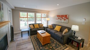 A living room with two sofas, a coffee table, a lamp, and a rug. - Pool and Hot Tub Access, Newly Renovated Suite with Free Parking, WiFi (Whistler)