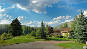 A residential property with a driveway, a house, and surrounding greenery. - Captivating Historic Cottage with Fireplace (Sun Valley)
