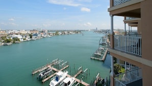 A marina with boats docked, a clear sky, and buildings in the background.