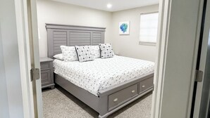A bedroom with a bed, nightstands, and a dresser. -  LOCATION! COMPLETE REHAB Great pool, close to north bean pt., twin family rooms (Anna Maria)