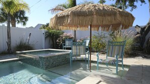 A swimming pool with a hot tub, two striped chairs, and a thatched umbrella. -  LOCATION! COMPLETE REHAB Great pool, close to north bean pt., twin family rooms (Anna Maria)