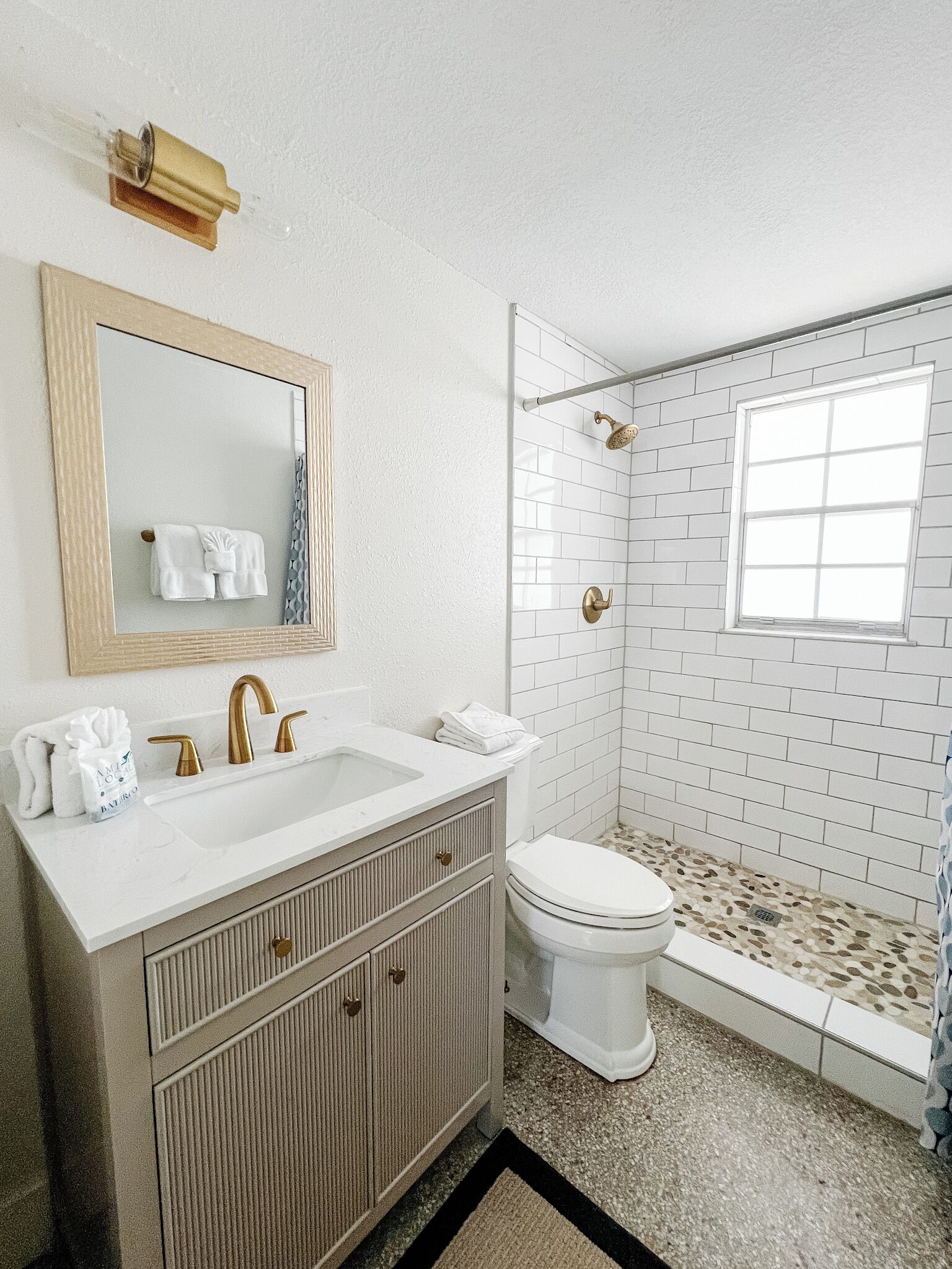 Un baño con lavamanos, tocador y inodoro blancos.