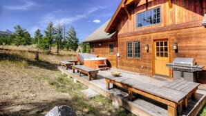 A wooden cabin with a deck, hot tub, and outdoor grill. - Mountain View | Hot Tub | Game Room (Big Sky)