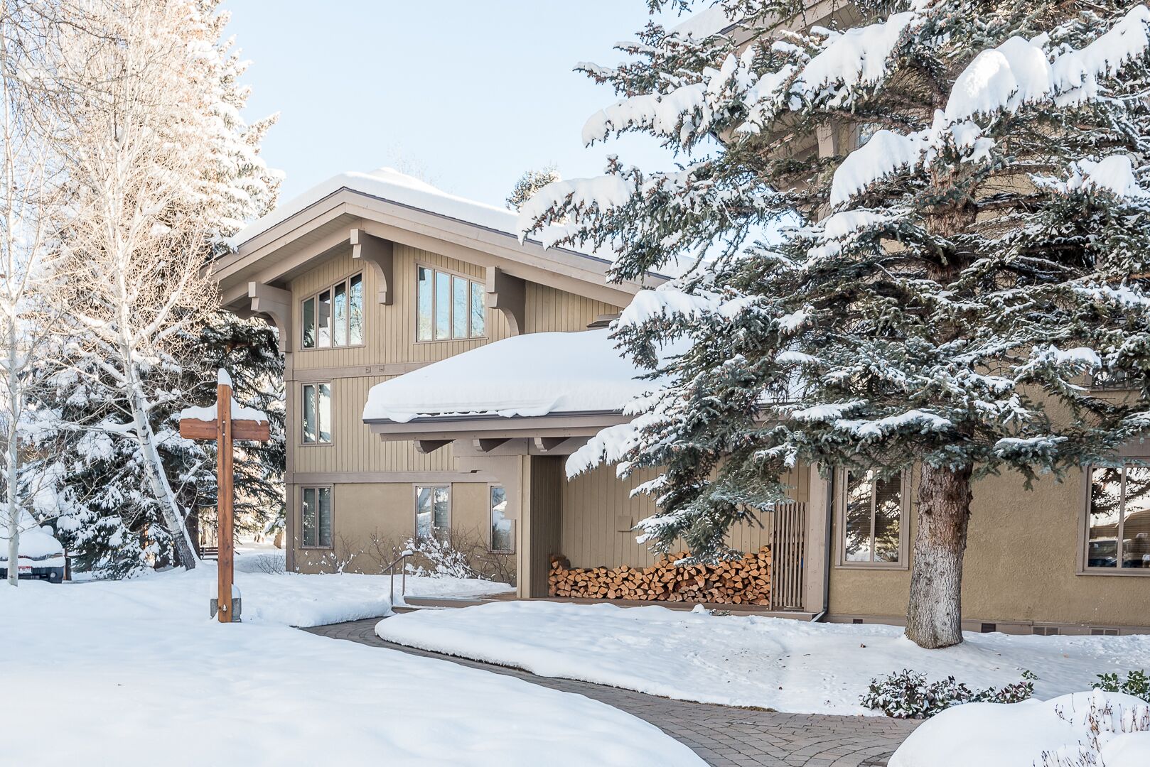 A two-story building with a snow-covered roof and a wooden deck.