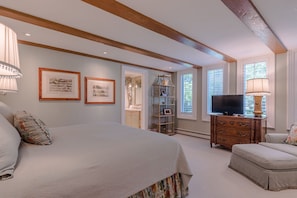 Relax in this classic room with a large bed, wooden dresser, and comfortable seating area.