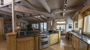 Uma cozinha ampla com armários de madeira, bancadas de granito e uma ilha grande.