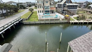 A residential area with a dock extending into a calm body of water, surrounded by houses with various architectural styles.
