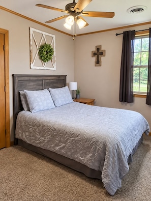 A bedroom with a bed, a ceiling fan, a cross on the wall, and a window with curtains. - The Cottage is on 450 acres w/hot tub, Private 4wheeler trails (Hatfield)