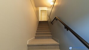 Ein Teppichgesteiger mit Handlauf, der zu einer Tür am oberen Ende führt.