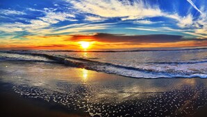 A beach with waves and a sunset. - Exquisite Home in Exclusive Community (Naples)