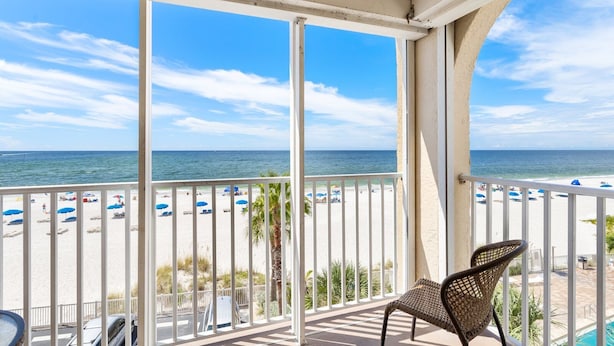 Un balcon avec vue sur une plage et l’océan.