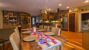 A spacious kitchen with wooden cabinets, a dining area with a large table, and a cozy seating arrangement. - Three bedroom/three bath resort style home with saltwater pool and spa  (Three Rivers)