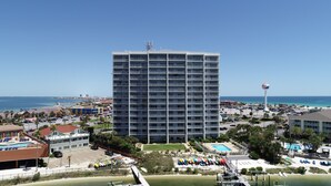 Um hotel moderno com vários andares, piscina e acesso à praia.