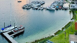 Uma marina com vários barcos atracados, céu claro e pôr do sol.