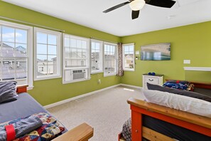 A bedroom with a bed, a wooden bench, a nightstand, and a ceiling fan. - ❤️ The Lucky Beach House! Steps to Beach, Restaurants, and Fun! Amazing Views! (Atlantic City)
