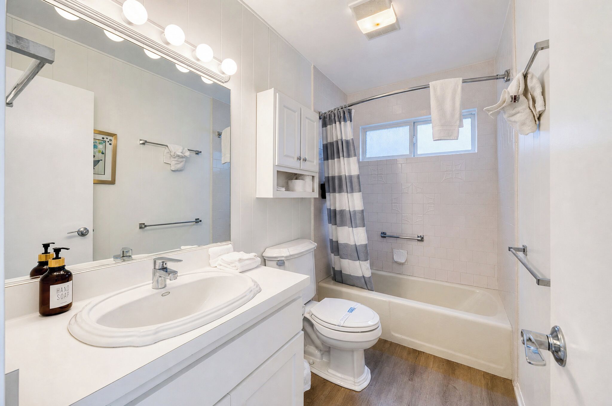 Une salle de bain avec deux éviers, des toilettes, une baignoire et un rideau de douche.