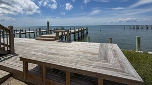A wooden pier extending into calm waters, with a clear sky above. - Out Of The Blue: Soundfront, spectacular sunsets, private boat dock. (Ocracoke)