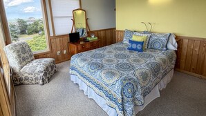 A bedroom with a bed, a chair, a dresser, a mirror, and a window with blinds. - Out Of The Blue: Soundfront, spectacular sunsets, private boat dock. (Ocracoke)