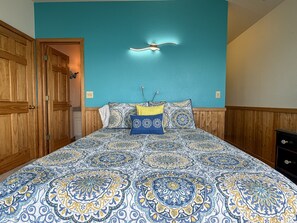 Ein Schlafzimmer mit einem großen Bett, einem Holzschrank und einer Wandleuchte.