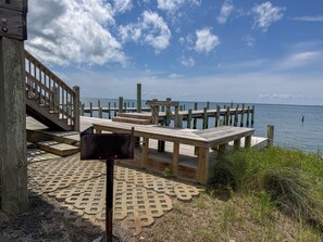 Eine Holzstege mit Bänken und einer Treppe, die zum Strand führt.
