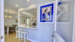 A modern kitchen with a white countertop, a large mirror, and a stained glass window. - 351D: Beautiful Restored Home, 2.5 Blocks from Downtown (Avalon)