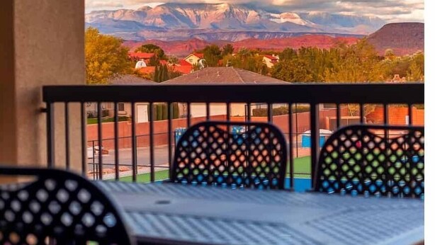 Un balcon avec vue sur les montagnes et la ville.