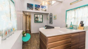 Eine moderne Küche mit Kochinsel, Holzschränken und Deckenventilator.