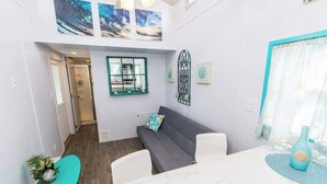 Ein modernes Interieur mit Essbereich, einer Couch und Kunstwerken an den Wänden.