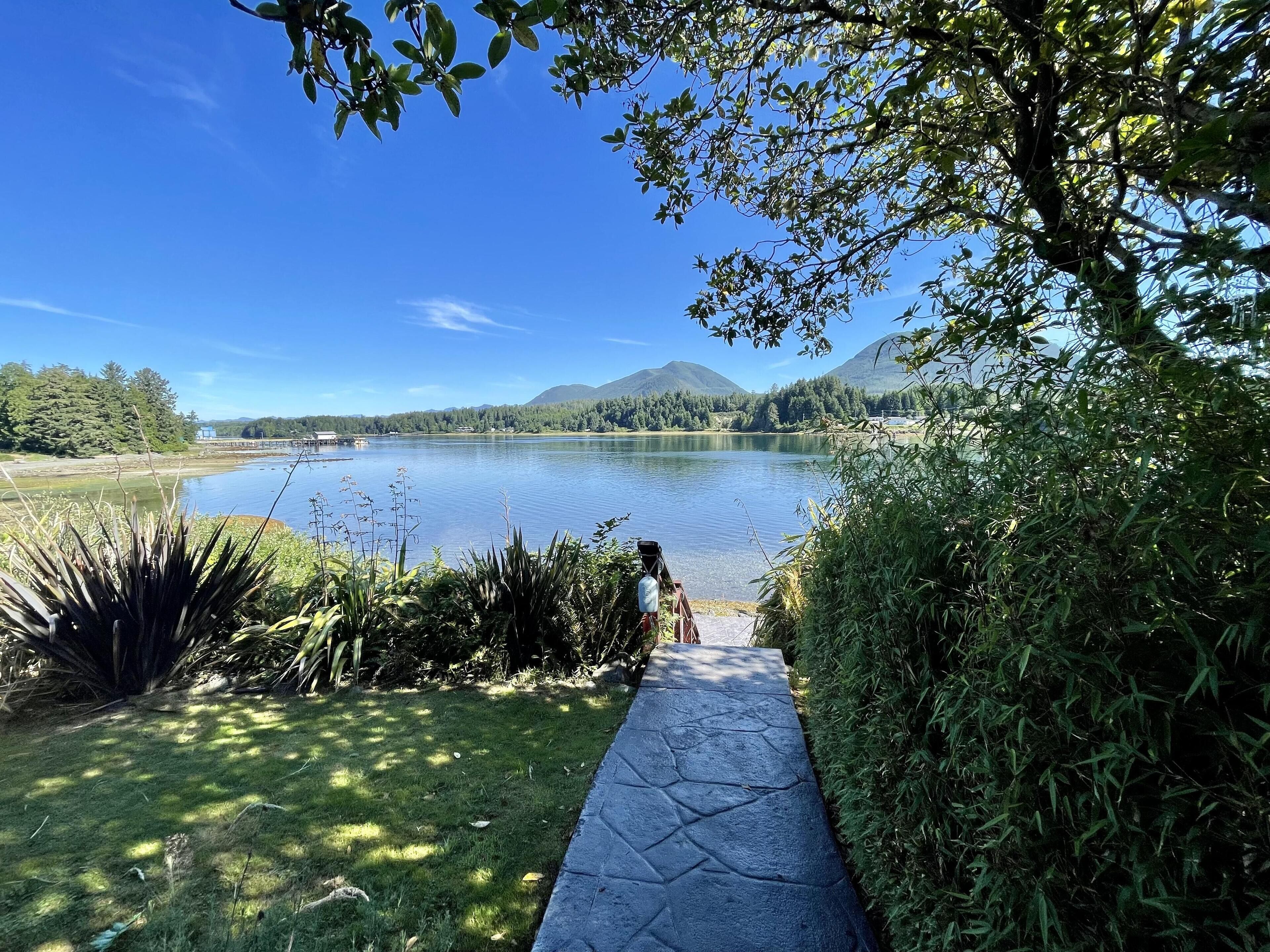 A pathway leading to a lake with a clear view of the water and surrounding greenery.