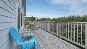 A wooden deck with a railing, a picnic table, and two Adirondack chairs. - 1523 - Moby Vic's - Whalehead Retreat, 200 Yards to Corolla Beach (Corolla)