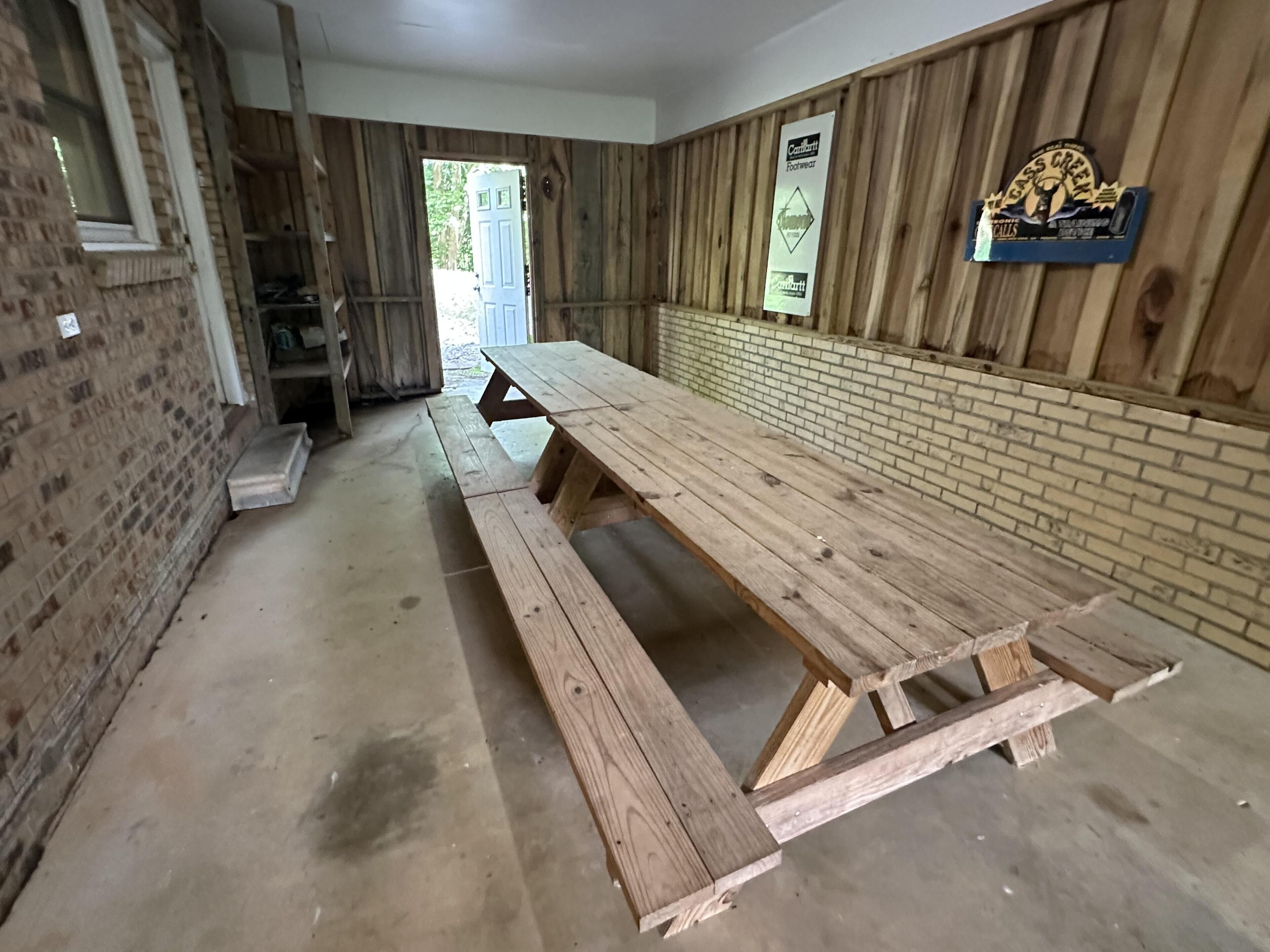 Una larga mesa de madera en una habitación con paredes de ladrillo y techo de madera.