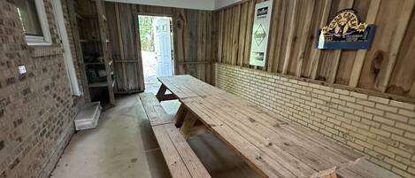 A long wooden table in a room with brick walls and a wooden ceiling.