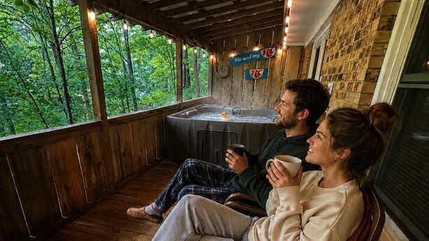 Eine Holzterrasse mit Blick auf Bäume, einem Whirlpool und einem Schild mit der Aufschrift 'Me and my RC'.