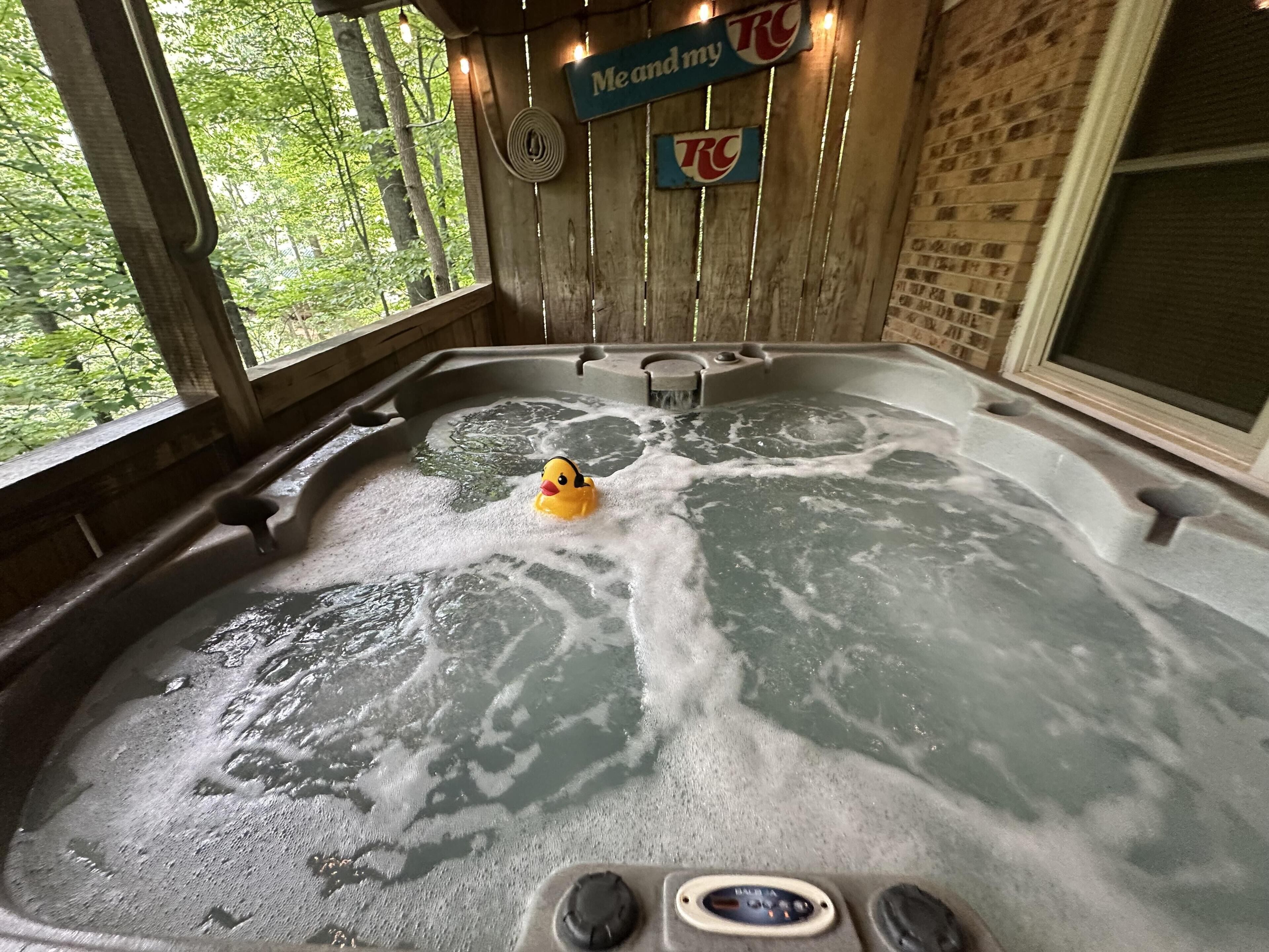 Un jacuzzi con un patito de goma, paredes de madera y un cartel que dice 'Yo y mi RC'.