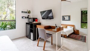 A modern bedroom with a bed, bedside table, and a TV mounted on the wall. - Contemporary suite in Santa Monica with private entrance (Santa Monica)