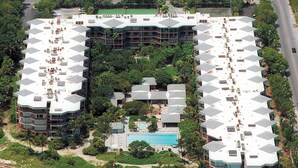 A hotel with multiple buildings, a central swimming pool, and surrounding greenery. - Vibrant Island retreat, Expansive private balcony, Enjoy  the Coastal Breezes (Key West)
