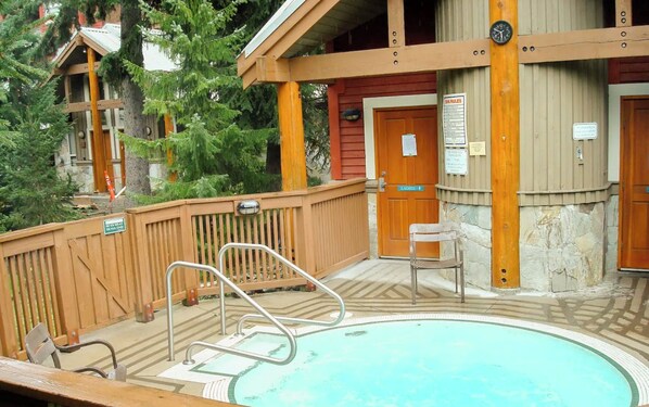 A wooden deck with a pool, a wooden chair, and a door labeled "Ladies."
