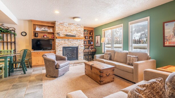 A cozy living room with a fireplace, comfortable seating, and a television.